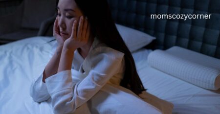 Woman sitting on bed overthinking situations late at night.