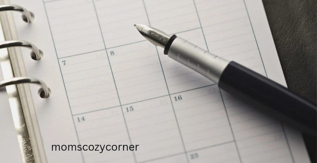 A silver fountain pen resting on an open monthly planner page with a clean, minimalist layout.