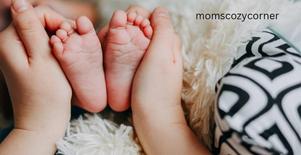 A mother's hands gently holding a baby's small feet.